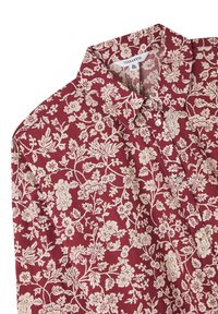 Blusa con motivo floreale rosso e colletto, caratterizzata da disegni botanici bianchi e due bottoni sulla parte frontale. Tessuto morbido.