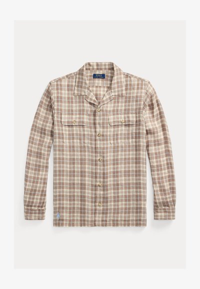 Ruda ir kreminė languota marškinėliai su ilgomis rankovėmis, dviem krūtinės kišenėmis ir auksinės spalvos sagomis; turi stovėjimo apykaklę ir mažą logotipo akcentą.