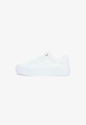 Witte lage sneaker met platte zool, veterlus aan de voorkant en een subtiel gouden "Tommy Hilfiger" logo aan de zijkant.