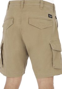 Pantalones cortos cargo en color beige con múltiples bolsillos laterales, dos bolsillos traseros, una cintura plana y detalles cosidos en toda la tela.