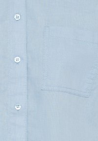 Light blue button-up shirt with a linen texture, featuring a patch pocket and four buttons on the placket, subtle stitching details.