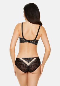 Czarny zestaw bielizny koronkowej z wzorem w zygzak, regulowanymi ramiączkami i zapięciem na haczyk. Projekt zawiera półprzezroczyste akcenty.