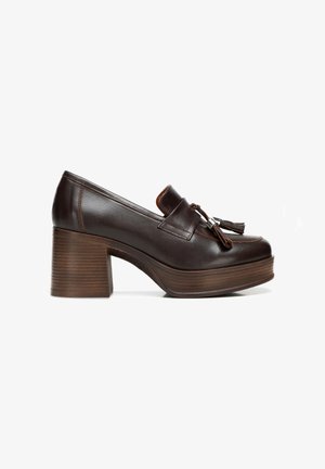 Scarpe platform in pelle marrone con tacco in legno spesso, caratterizzate da una punta arrotondata e accenti decorativi a frange sulla parte superiore.