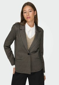 Brown plaid blazer with a notched collar, single button closure, and two front pockets, layered over a cream knit vest and white shirt.