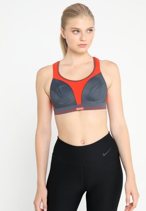 Sutiã desportivo com um esquema de cores em vermelho e cinza e um design texturizado. Possui alças largas, uma forma que oferece suporte e um logótipo na banda.