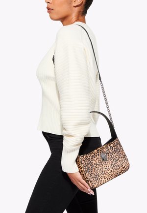 Sac à main en imprimé léopard avec une bandoulière noire et un accent de chaîne en argent, de forme rectangulaire, texture lisse, maintenu contre un pull de couleur claire.