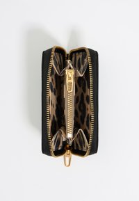 Cartera negra con cremallera dorada, con un interior de estampado de leopardo. Compartimento con cremallera y dos bolsillos internos para organización.