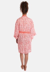 Rode kimono met bloemmotief en losse mouwen, met een stevige band om de taille. Bevat een mix van bloemen- en golvende lijnontwerpen.
