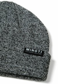 Szürke kötött sapka, texturált mintával, fekete címkével, fehér felirattal: „MINOTI OUTDOOR EDITION.”