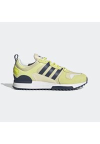 Lime green and navy running shoe with mesh and suede materials, featuring three navy stripes, a textured sole, and a heel tab for easy wear.