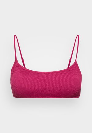 Bralette fucsia con un diseño texturizado y acanalado, y tirantes delgados ajustables. Ofrece un aspecto sin costuras y un ajuste cómodo.