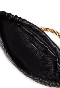 Innenseite einer schwarzen Lederhandtasche, ausgestattet mit einem strukturierten Futter, einer Einschubtasche und einem Akzent aus goldenem Kettenriemen. Weiche, geraffte Kanten.