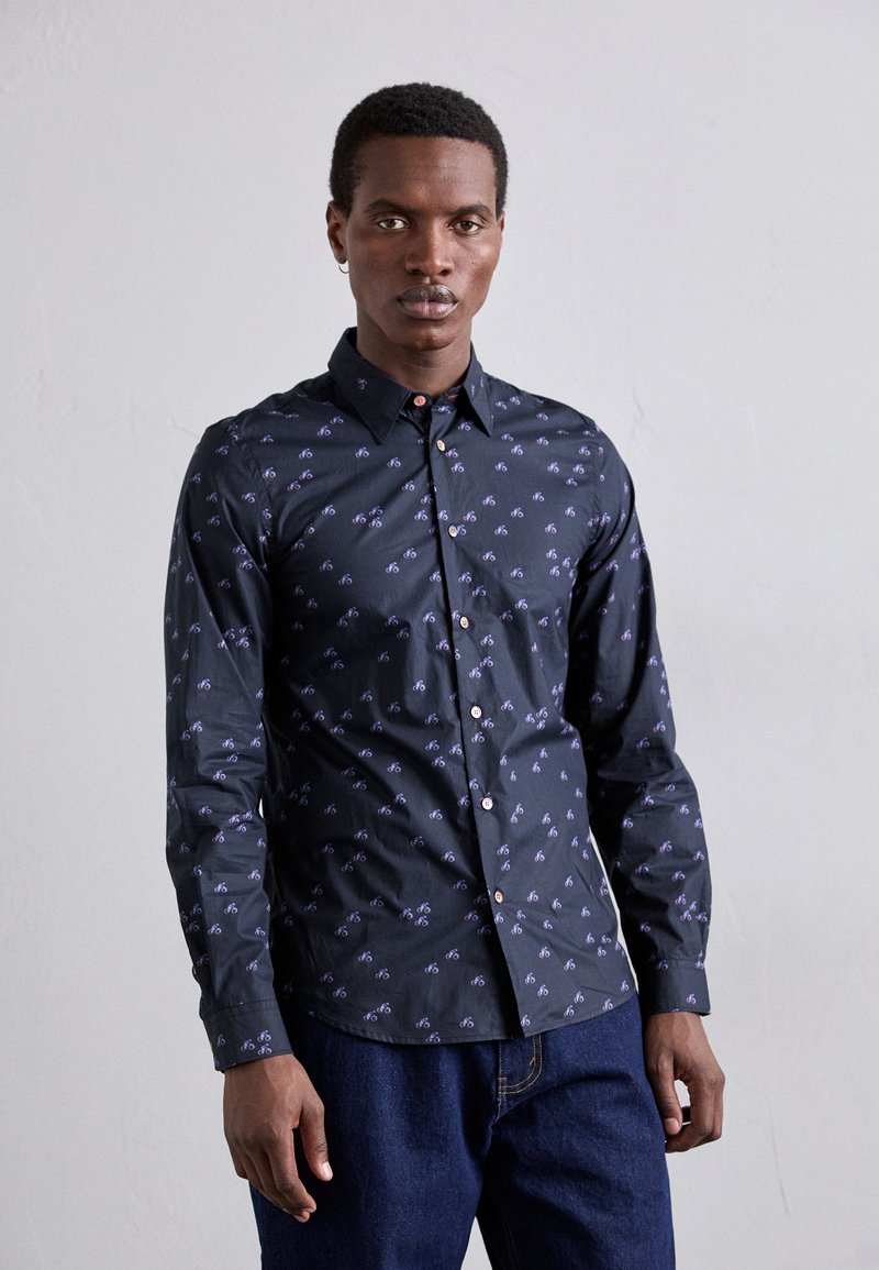 Camicia button-up di un blu scuro con un sottile motivo di biciclette, maniche lunghe e colletto classico. Il tessuto sembra liscio e leggero.
