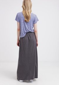 Gestreiftes blau-weißes Kurzarm-Oberteil, kombiniert mit einem langen, grauen Rock mit elastischem Bund. Hauptsächlich aus Baumwolle, lockere Passform, glatte Textur.