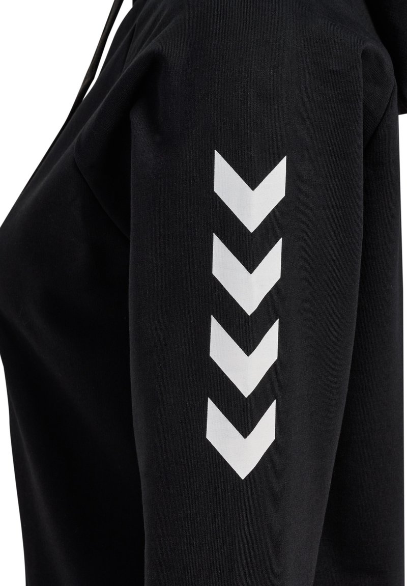 Czarna bluza z kapturem o miękkiej teksturze, z białym wzorem chevron na górnej części rękawa. Kaptur ze sznurkiem i luźny krój.