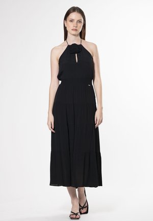 Schwarzes Halterneck-Kleid mit einem Schlüssel-ausschnitt, strukturiertem Stoff und gestuftem Rock. Hat eine florale Akzentuierung am Ausschnitt. Bodentiefe Design.