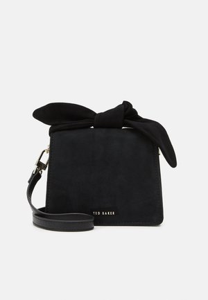 Petit sac à poignée rectangulaire noir avec un grand nœud en tissu sur le dessus et une bandoulière amovible, logo Ted Baker à l’avant.