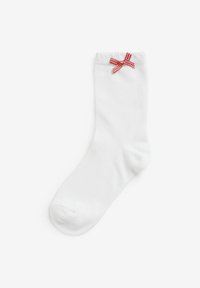 Weiße Baumwollsocke mit strukturiertem Oberflächen, ausgestattet mit einer roten Gingham-Schleifenakzent am Saum. Klassisches Design bis zur Mitte der Wade.