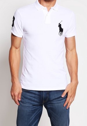 Weißes Polohemd mit einer Zwei-Knopfleiste und einem schwarzen, auf der Brust gestickten Pferdelogo. Aus Baumwollmaterial, mit kurzen Ärmeln und regulärer Passform.