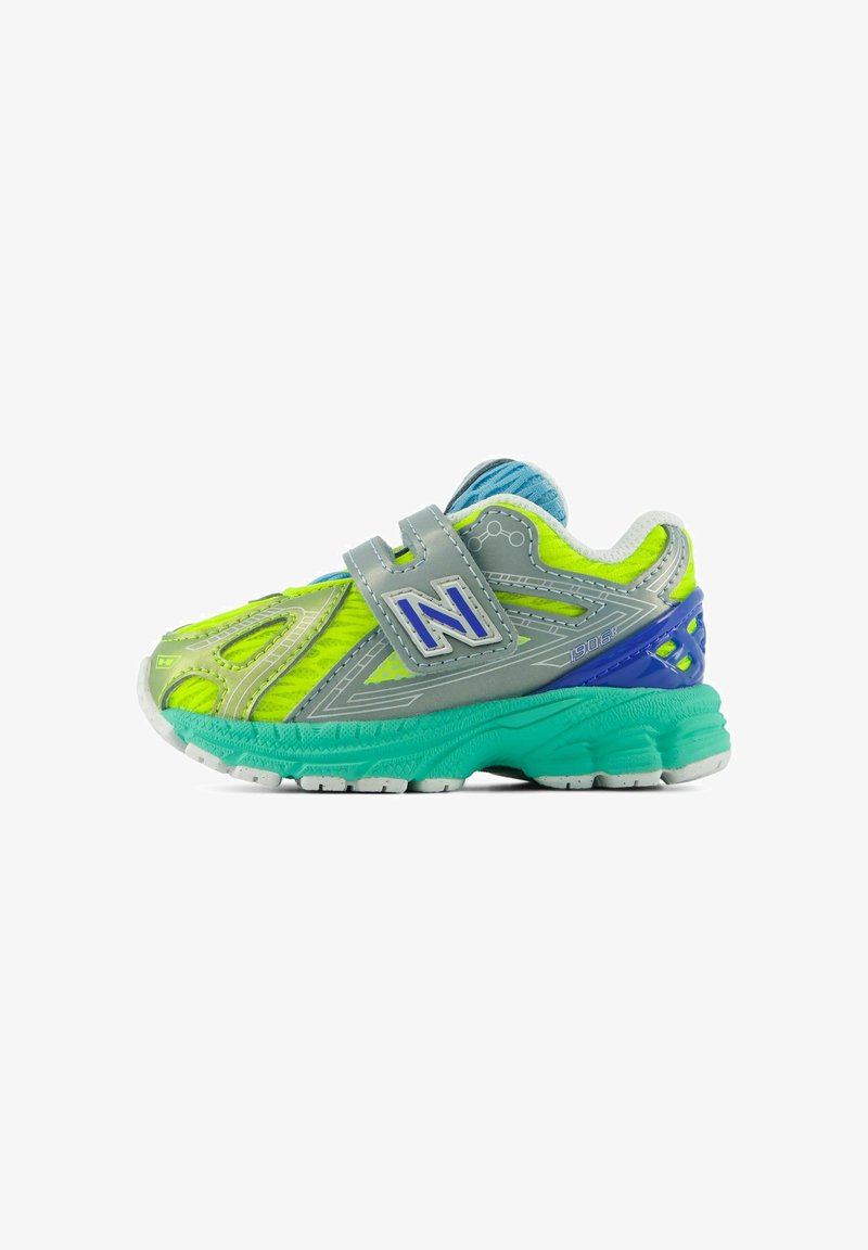 Scarpa sportiva per bambini di colore giallo neon e grigio con suola turchese, dettaglio sul tallone blu e cinturino in velcro con logo "N" blu.