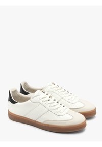 Sneaker bianchi in pelle con finitura strutturata, dettagli neri sul tallone, suola in gomma e lacci piatti. Presentano pannelli laterali e dettagli di cucitura.