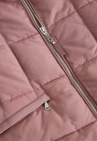 Padded jakna od mekane rozé tkanine s aluminijumskim patent zatvaračem, kviltanim uzorkom i unutrašnjim džepom sa zatvaračem.