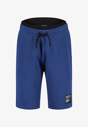 Pantaloncini blu fino al ginocchio con cintura elasticizzata, coulisse nera, tasche laterali e una piccola toppa "Decoded Reality" sulla gamba sinistra.