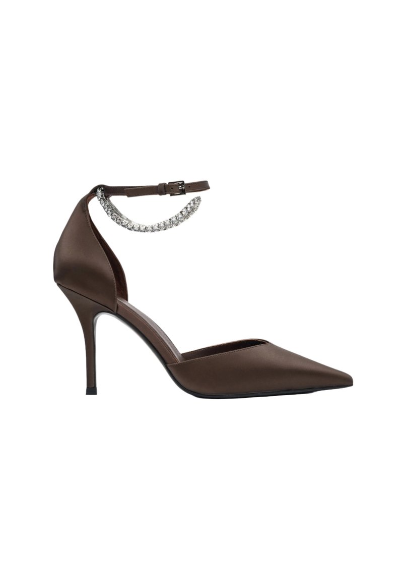 Brown satin high-heeled pump with a pointed toe, ankle strap, and a decorative chain detail. Smooth texture with a sleek design.
