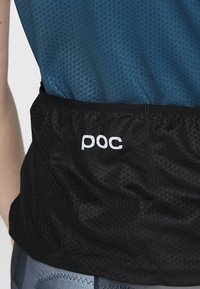 Musta urheilupaita, jossa on tekstuurilla varustettu muotoilu ja sininen yläosa. Brändi "poc" on esillä valkoisena takahieman kohdalla.