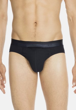Schwarze Herrenunterhosen aus einem Stoff mit glatter Textur. Sie verfügen über einen breiten Bund mit eingeprägtem Markenlogo und einer konturierten Vorderseite.