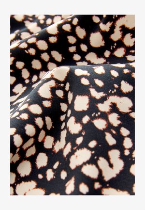 Čierna látka s potlačou leopardieho vzoru, ktorá obsahuje veľké béžové škvrny obklopené tmavohnedým lemovaním, s hladkou textúrou a matným povrchom.