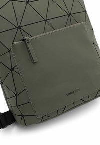 Zielony plecak z geometrycznym, trójkątnym wzorem, z zamykaną na zamek kieszenią z przodu i skórzanym wykończeniem. Wyświetlona nazwa marki.