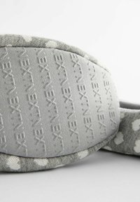 Grijze stoffen slipper met een gevlekt patroon, zachte textuur en een structuurondergrond met verhoogde letters. De ronde vorm verhoogt het comfort.