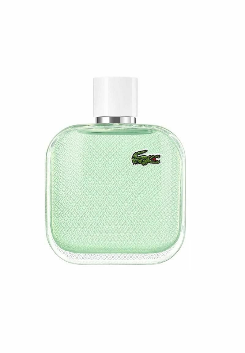 Grön glasparfymflaska med fyrkantig form, texturerad yta, vit kork och en liten broderad krokodil-logotyp.