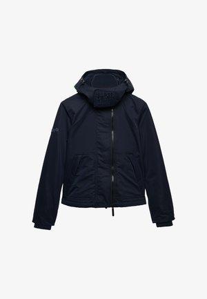 Marineblå hættejakke med frontlynlås, to skrå lommer, ribstrikkede ærmegab og "Superdry"-logo på nakkelappen og venstre ærme.