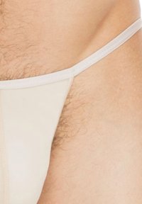 Beige Strings aus weichem Stoff, mit einem schmalen elastischen Bund und minimaler Abdeckung, unauffälligen Nähten und ohne Muster.