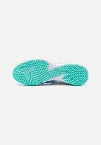 Suola di una sneaker bianca con una suola in gomma turchese texturizzata, caratterizzata da un motivo di piccole macchie e stelle per migliorare la trazione.