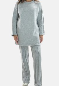 Szary zestaw z tuniki i spodni wykonanych z miękkiego materiału. Tunika ma okrągły dekolt; spodnie zdobią pionowe paski na całej długości.