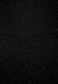 Svart strukturerad tyg med ett subtilt diamantmönster, med en slät finish och en figurnära design. Inga synliga detaljer eller accenter.