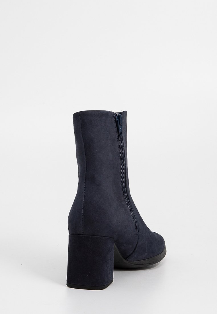 Marineblauwe enkelboot met een textuur van suede, blokhak en ritssluiting aan de zijkant. Klassiek ontwerp met een slanke silhouet.