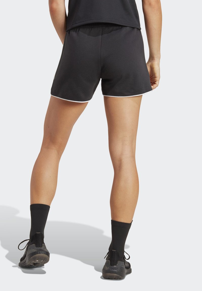 Schwarze Sportshorts mit einem engen Bund, weißen Paspeln am Saum, kombiniert mit schwarzen Socken und Turnschuhen, zeigen eine glatte Stofftextur.