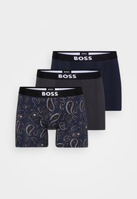 Drei Paare Herren-Boxershorts. Eine hat ein blaues Paisleymuster; die anderen sind einfarbig in Dunkelblau und Grau. Alle haben einen schwarzen Bund mit "BOSS"-Logo.