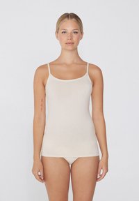 Beige tank top with thin straps, made of soft fabric. Straight cut design, smooth texture, and no visible patterns or hardware details.