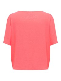 Haut à manches courtes corail rose avec une coupe ample et des petites paillettes subtiles dispersées sur le tissu.