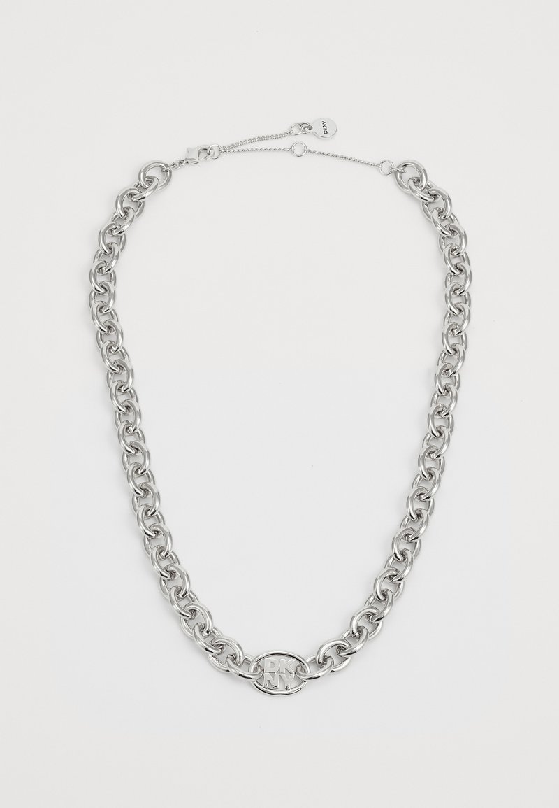 Colar de links prateados com um pendente oval do logo DKNY, grandes elos de corrente, um acabamento metálico suave e um fecho com corrente ajustável.