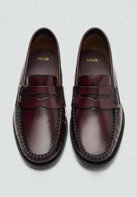 Bordowe mokasyny ze skóry o gładkim wykończeniu, ozdobnym przeszyciu i podzielonym wzorze na górnej części. Fakturalna podeszwa dla lepszej przyczepności.