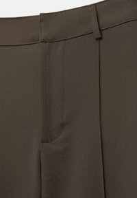 Pantaloni marroni su misura con tessuto liscio, davanti piatto e tasca laterale. La vita è strutturata con una finitura pulita.