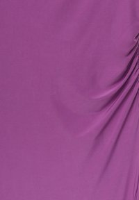 Gros plan sur un tissu violet lisse avec des plis froncés sur le côté droit créant des plis doux et de la texture.