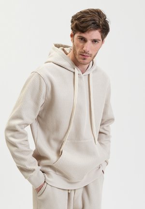 Beige hoodie made of ribbed fabric, featuring a front pocket, adjustable drawstring hood, and long sleeves with ribbed cuffs.