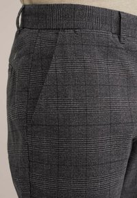 Grijze geruite broek met een gestructureerde stof en een subtiel patroon, elastische tailleband en zijzakken voor functionaliteit.